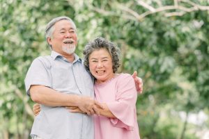 happy senior couple holding each other park