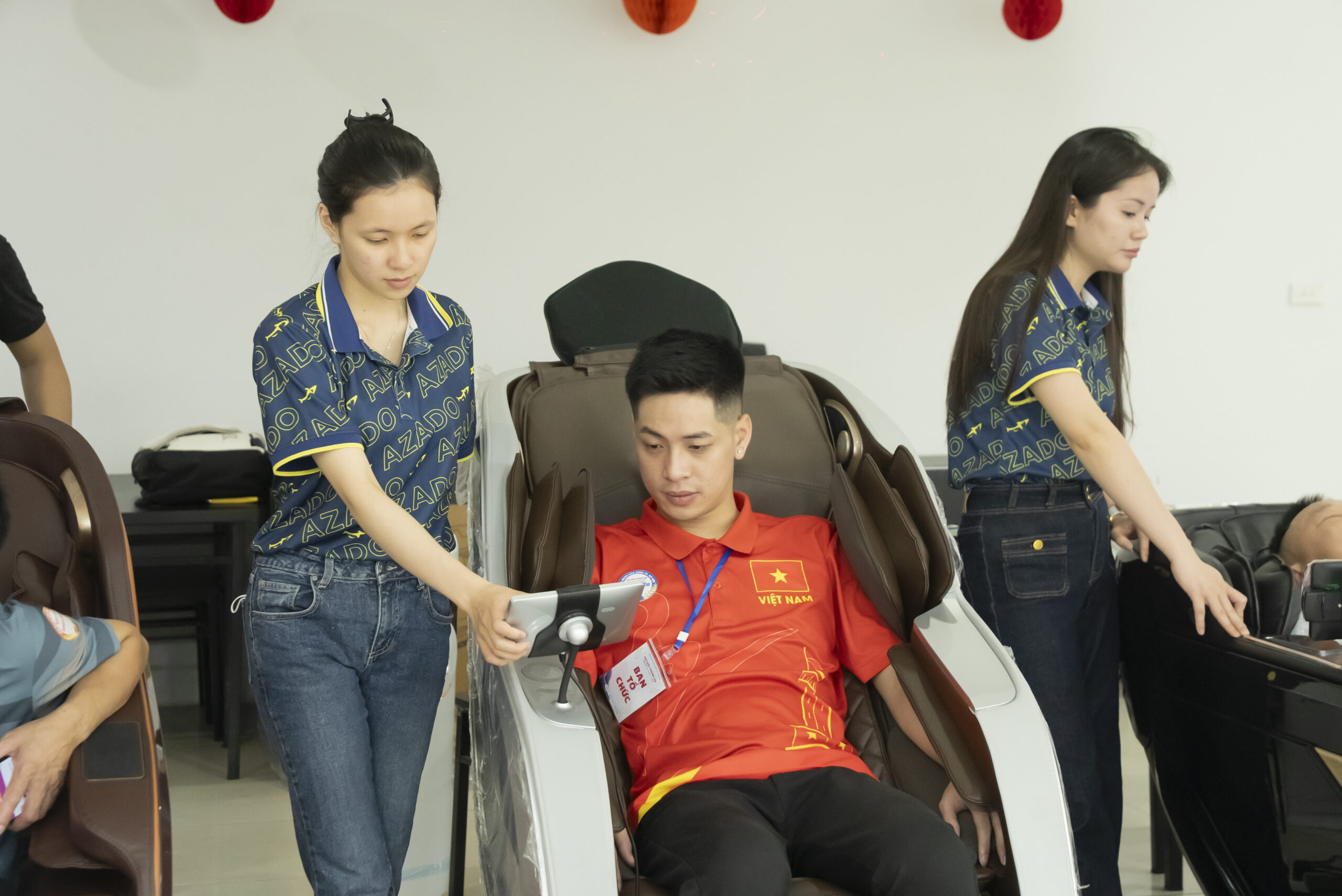 Các vận động viên và đại biểu trải nghiệm sự thư giãn tuyệt vời trên ghế massage AZADO ngay tại sự kiện.